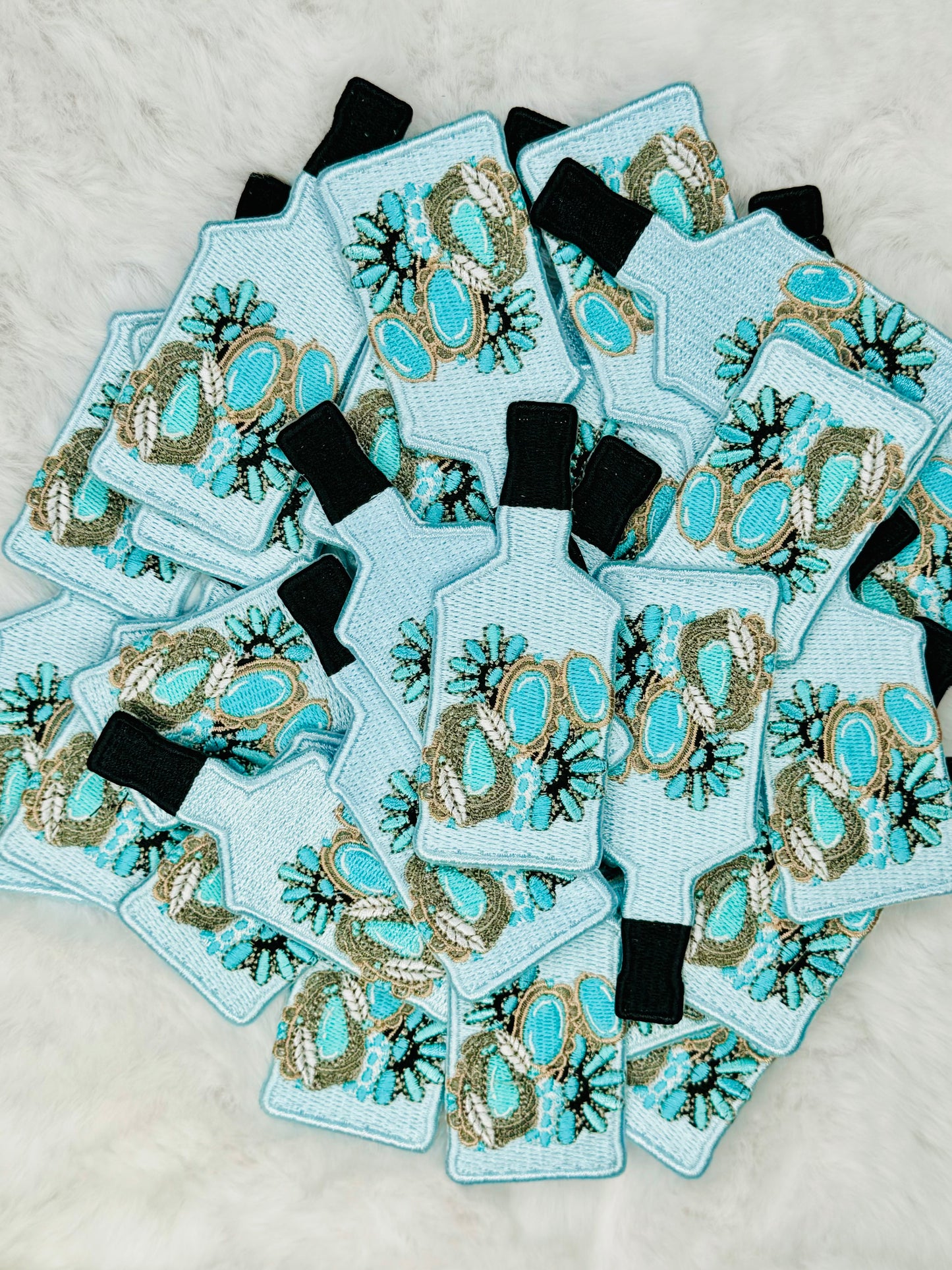A stack of the Bottle of Turquoise Jewels Embroidered Patch