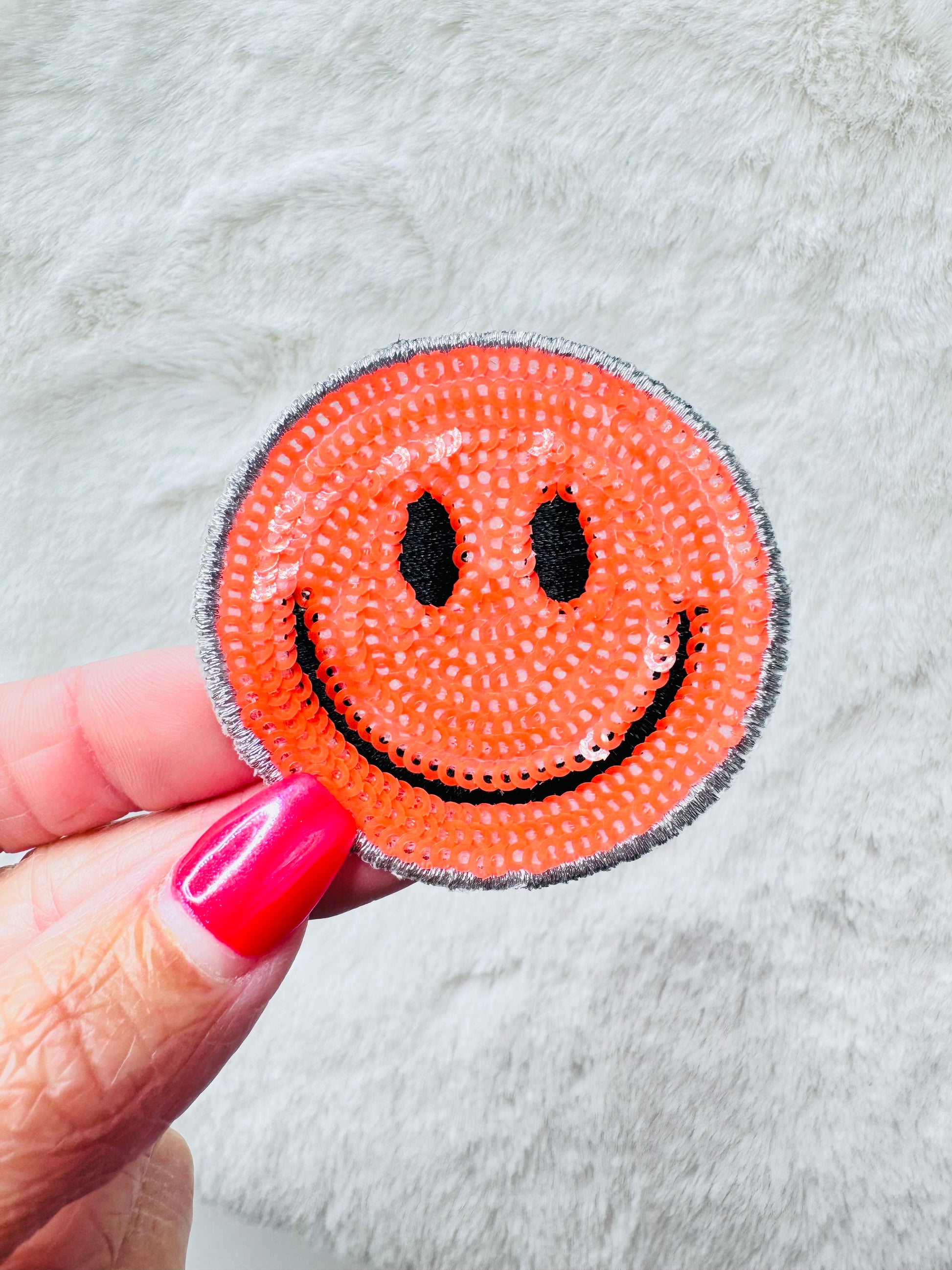 Orange sequin smiley face