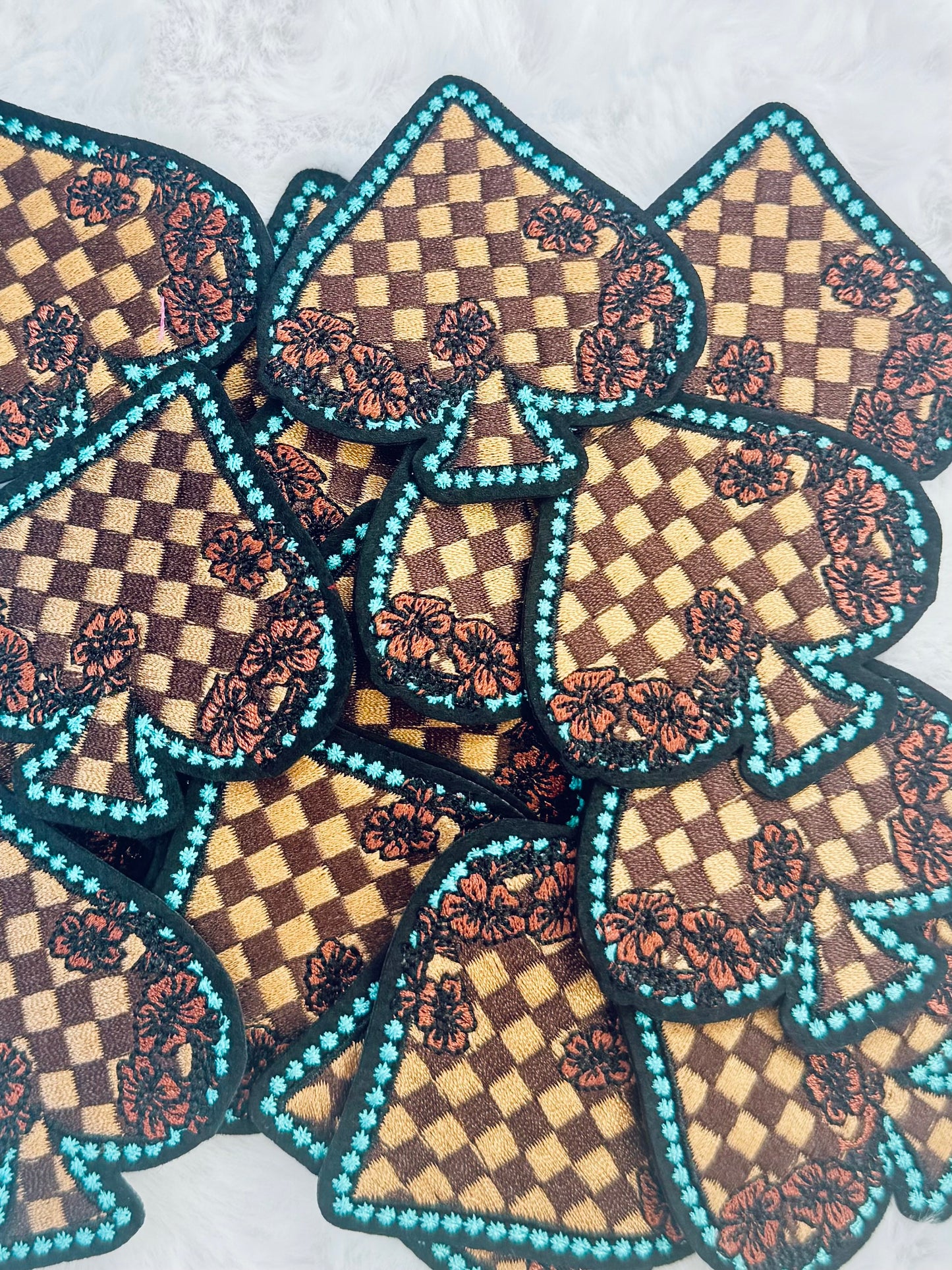 A stack of the Checkered Floral Spade Embroidered Patch