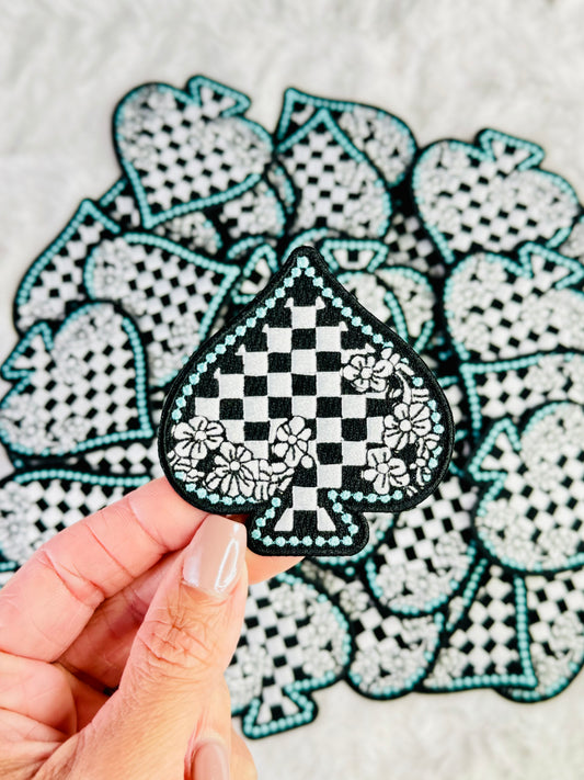 An up close photo of the Black & White Checkered Floral Spade Embroidered Patch