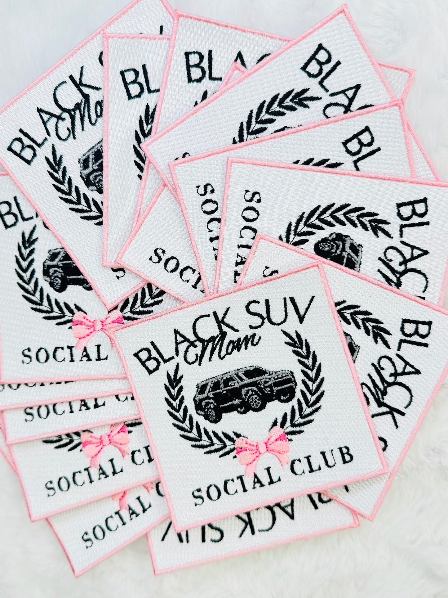 A stack of the Black suv mom social club patch