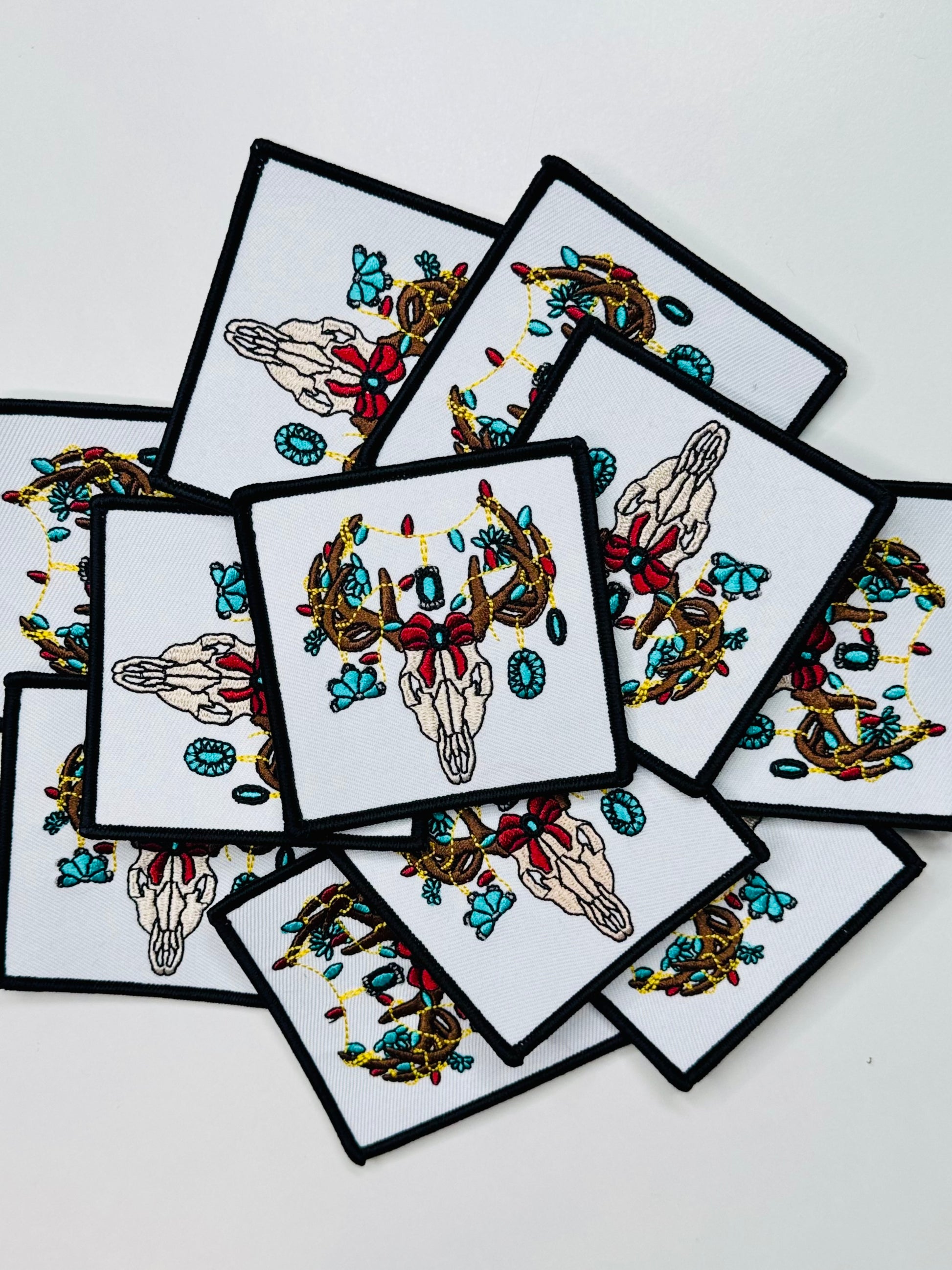 A stack of the Bull Skull Decorated In Turquoise Jewels Embroidered Patch