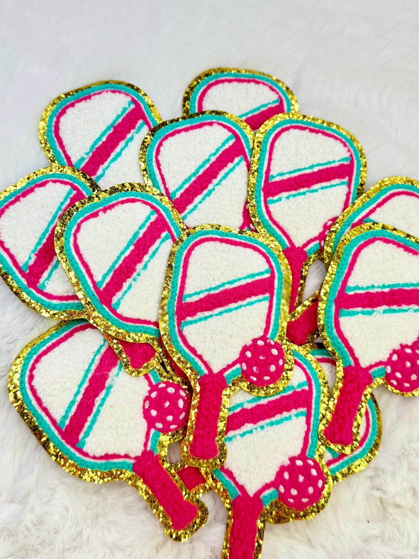 A stack of the pickle ball paddle Chanel patch