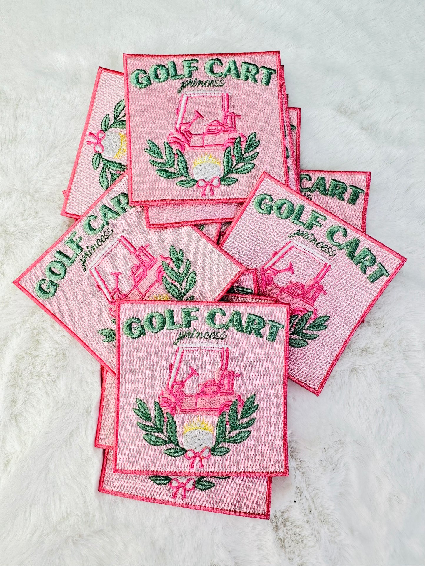 A stack of the golf cart, princess pink embroidered patch