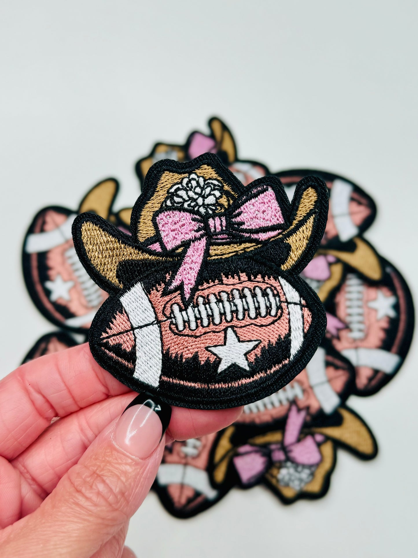 An up close phot of the Coquette Western Football Embroidered Patch