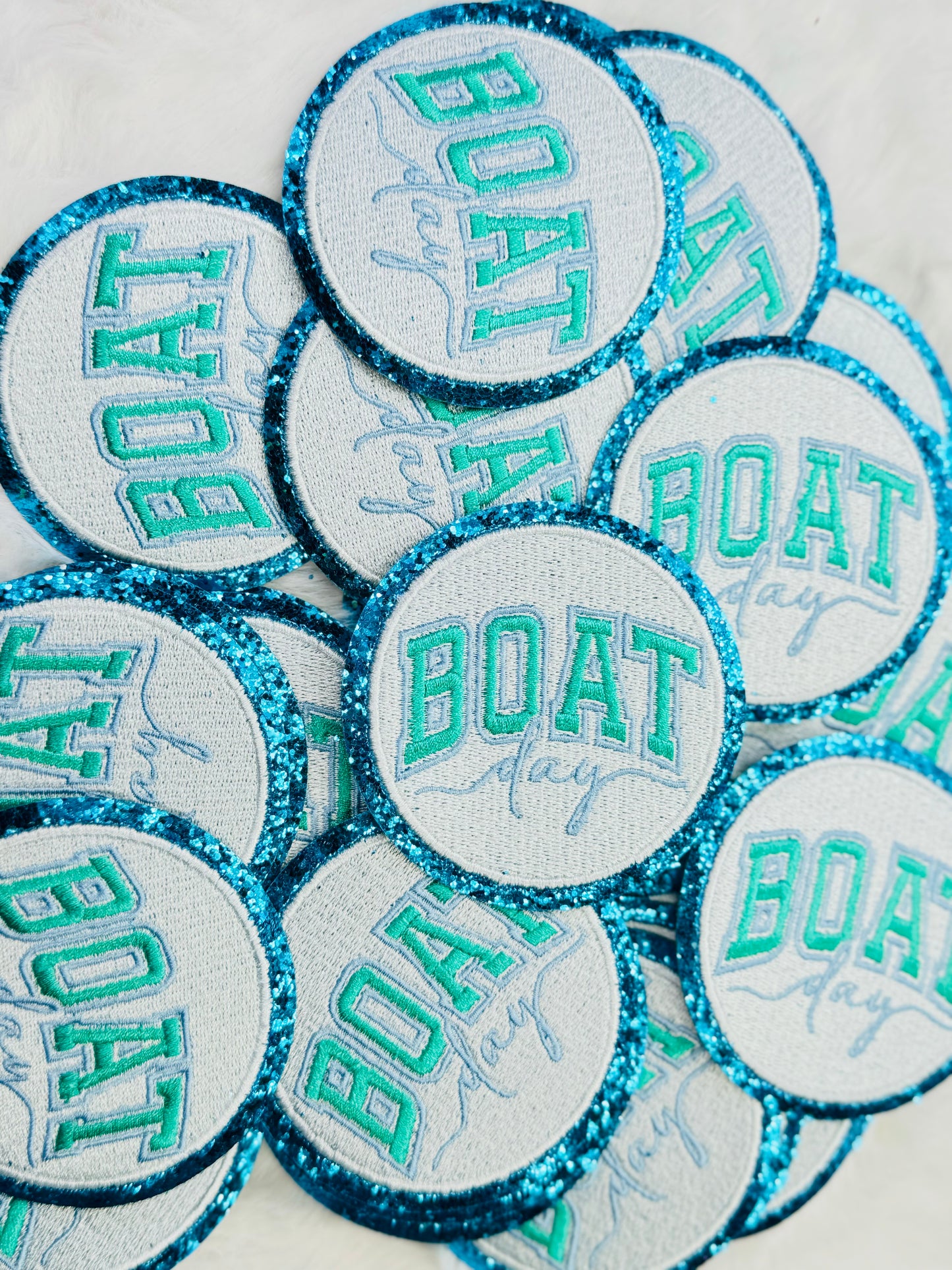 A stack of the Boat Day Glitter Embroidered Patch