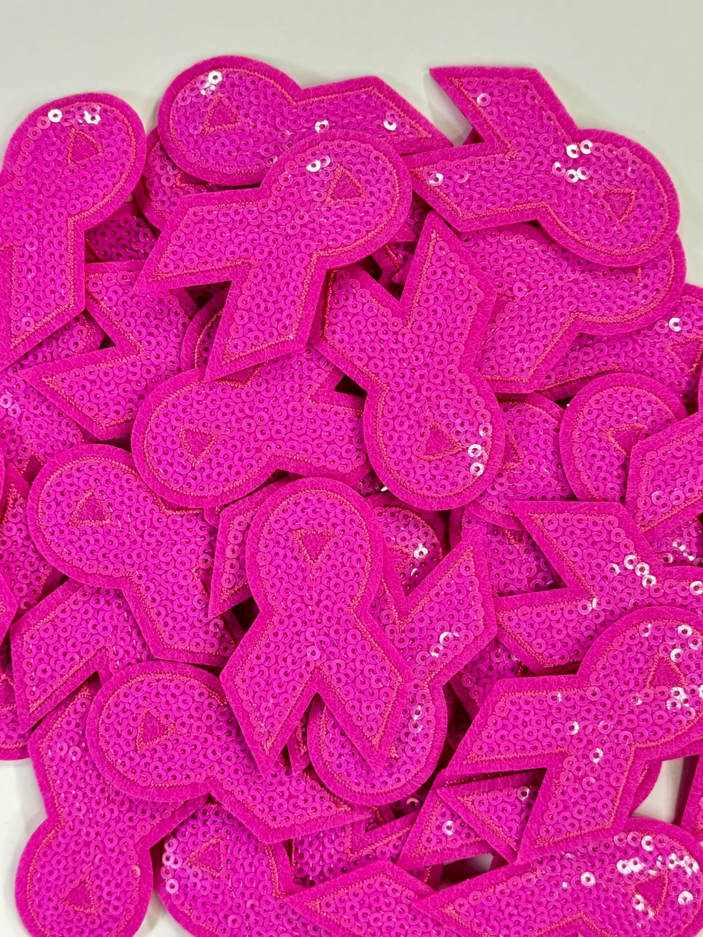 An up close photo of the pink sequins awareness ribbon patch