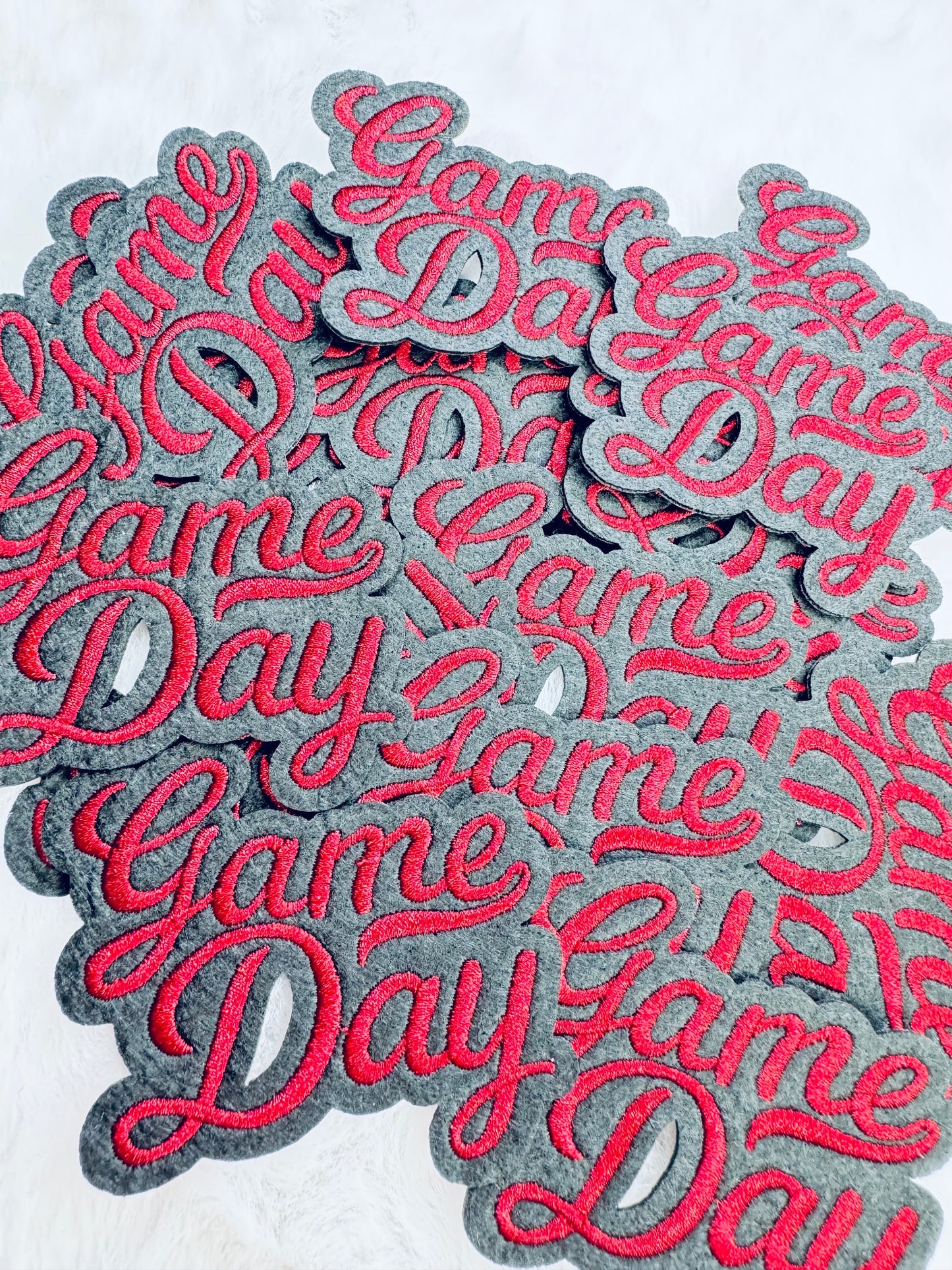 A stack of the Red Game Day Embroidered Patch
